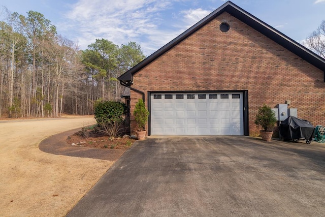 view of home's exterior featuring brick siding and a garage