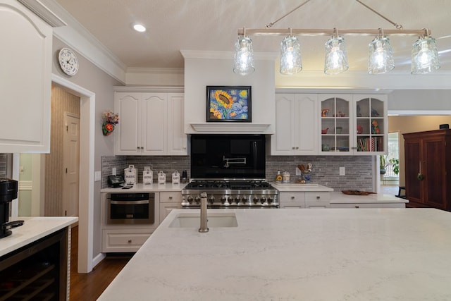 kitchen with oven, a sink, wine cooler, crown molding, and range