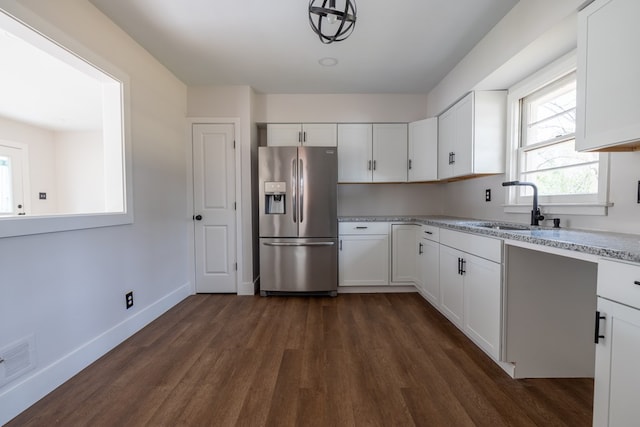 kitchen featuring white cabinets, stainless steel refrigerator with ice dispenser, and a sink