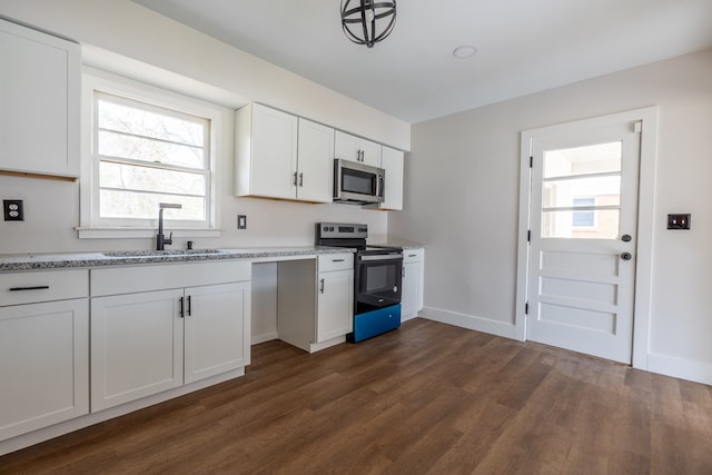 kitchen featuring appliances with stainless steel finishes, dark wood finished floors, white cabinets, and a sink