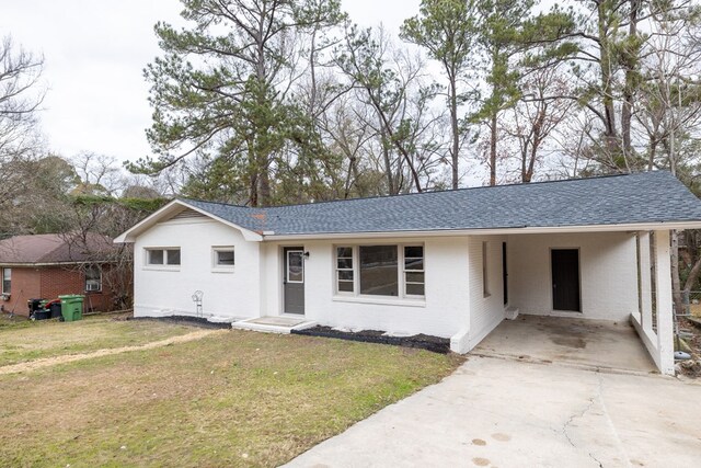 single story home with a shingled roof, concrete driveway, a front lawn, a carport, and brick siding