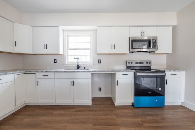 kitchen with appliances with stainless steel finishes, dark wood finished floors, white cabinets, and a sink