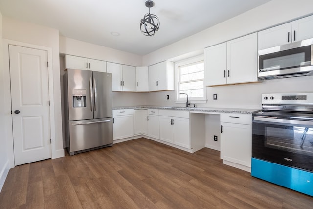 kitchen with appliances with stainless steel finishes, white cabinets, dark wood finished floors, and a sink