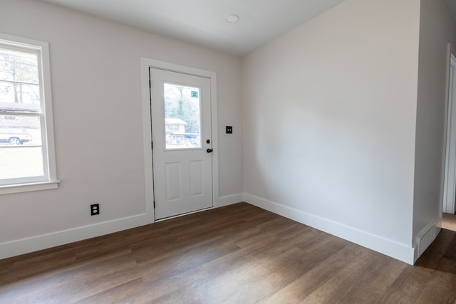 doorway to outside featuring baseboards and wood finished floors