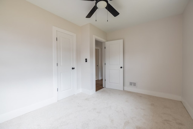 unfurnished bedroom with light carpet, baseboards, visible vents, and a ceiling fan