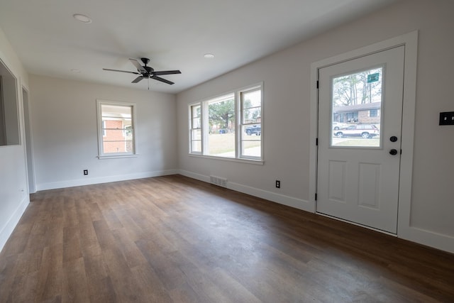 foyer entrance with dark wood-style floors, visible vents, ceiling fan, and baseboards