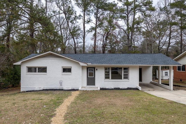 ranch-style home featuring brick siding, a front lawn, and roof with shingles