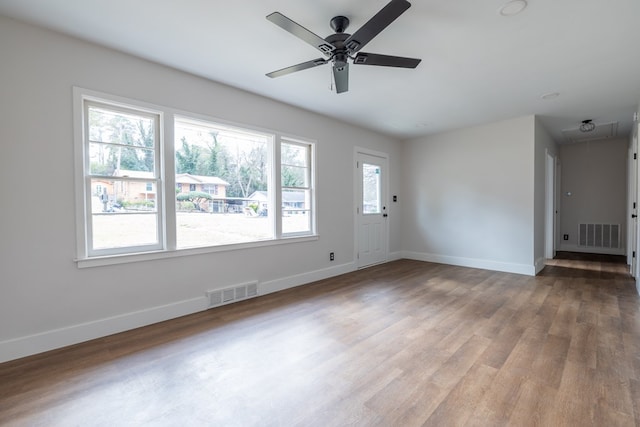 interior space featuring baseboards, attic access, visible vents, and wood finished floors