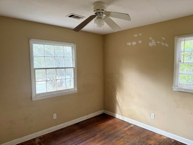 spare room with dark hardwood / wood-style flooring and ceiling fan