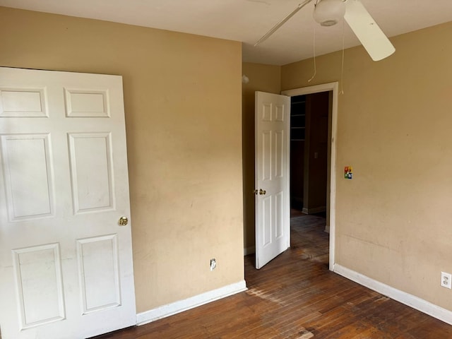 unfurnished bedroom featuring ceiling fan and dark hardwood / wood-style floors