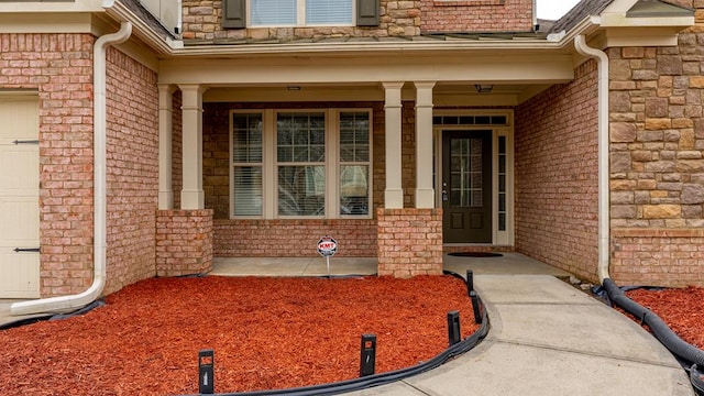 doorway to property with covered porch and a garage