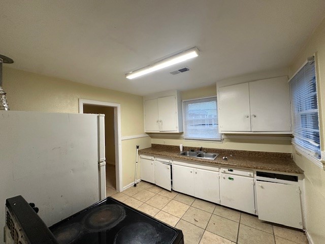 kitchen featuring white appliances, white cabinetry, sink, and light tile patterned floors