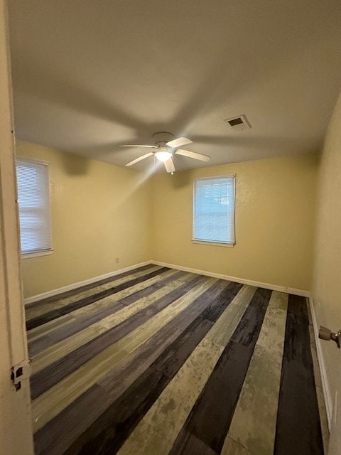 empty room with hardwood / wood-style flooring and ceiling fan