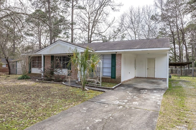 view of front of house featuring a carport, concrete driveway, and brick siding