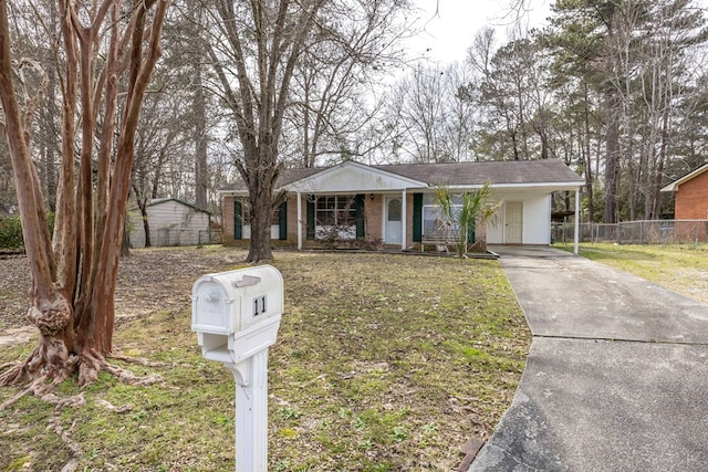 view of front facade featuring concrete driveway, brick siding, fence, and a front lawn