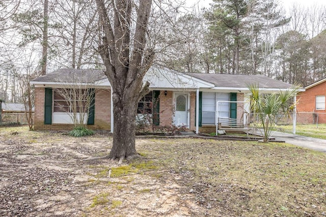 ranch-style home featuring fence and brick siding