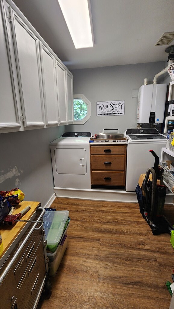 4232 Almond Rd, Fortson, GA 31808 - laundry room featuring wood finished floors, washer and clothes dryer, cabinet space, and tankless water heater