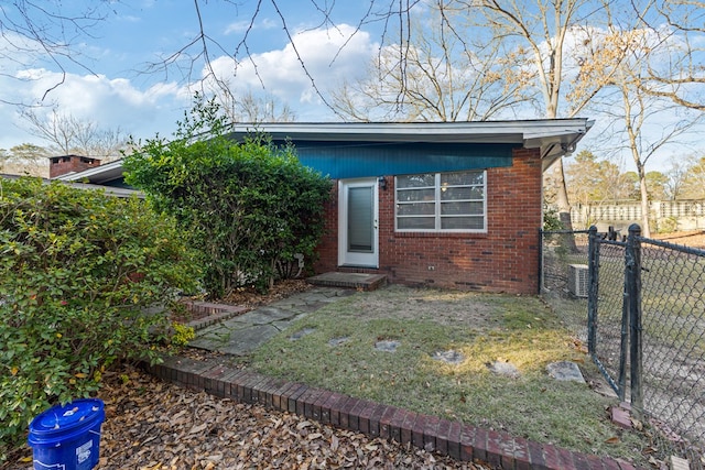 view of front of property with fence private yard, a front yard, and brick siding