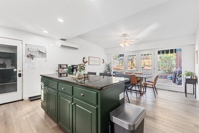 kitchen with recessed lighting, light wood-style floors, green cabinets, a center island, and a wall mounted air conditioner