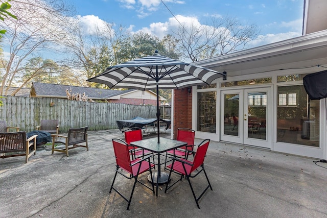 view of patio / terrace featuring outdoor dining space, french doors, cooling unit, and fence