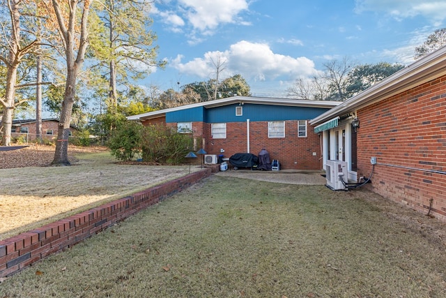 rear view of house with brick siding and a lawn