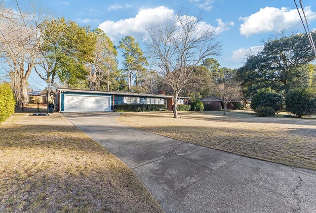 ranch-style home with a garage, concrete driveway, and a front lawn