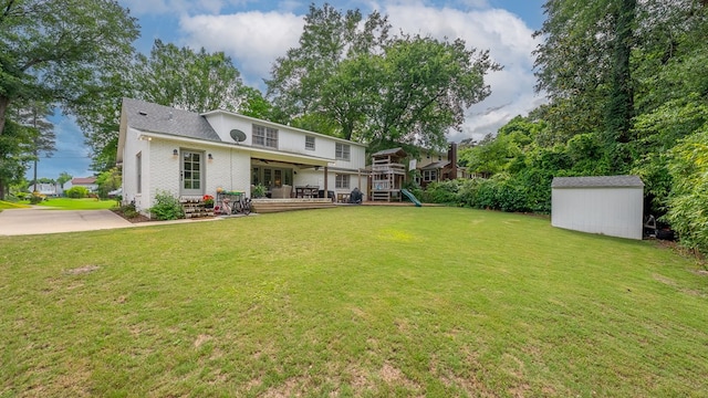 back of house with brick siding, a storage shed, a playground, an outdoor structure, and a lawn