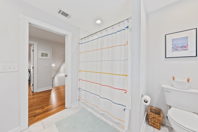 full bathroom featuring toilet, baseboards, and a shower with shower curtain