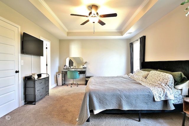 carpeted bedroom with ornamental molding, ceiling fan, and a raised ceiling