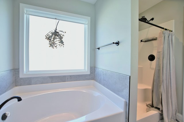 bathroom featuring shower with separate bathtub