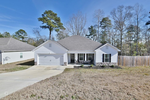 ranch-style house featuring covered porch, a front yard, and a garage