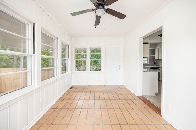 unfurnished sunroom with ornamental molding and tile patterned floors