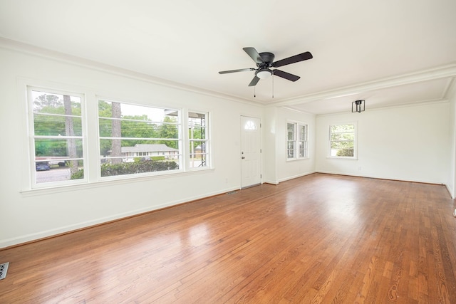 spare room with baseboards, a ceiling fan, wood finished floors, and visible vents