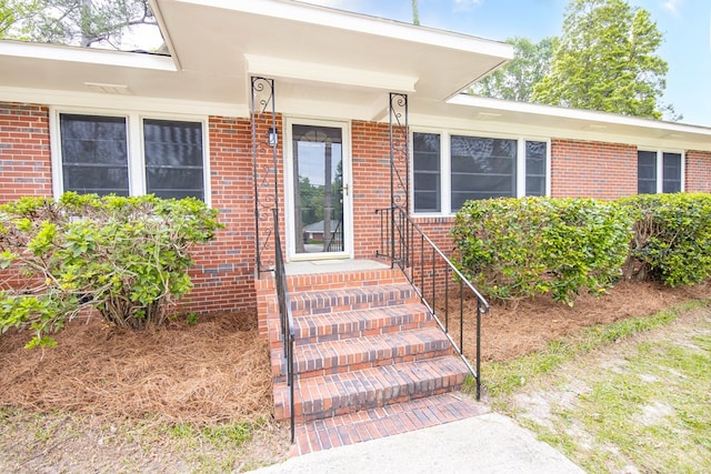property entrance featuring brick siding