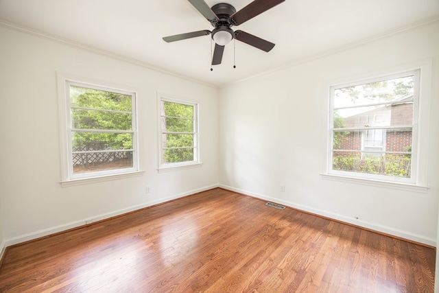 unfurnished room with baseboards, light wood-style flooring, visible vents, and crown molding