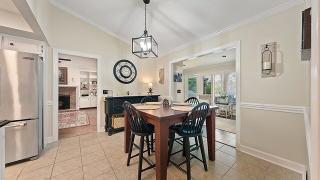 6359 Cape Cod Dr, Columbus, GA 31904 - dining room with crown molding, light tile patterned flooring, a brick fireplace, and a chandelier