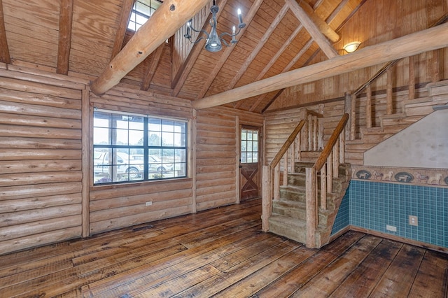 spare room with dark wood-type flooring, log walls, high vaulted ceiling, wooden ceiling, and beamed ceiling