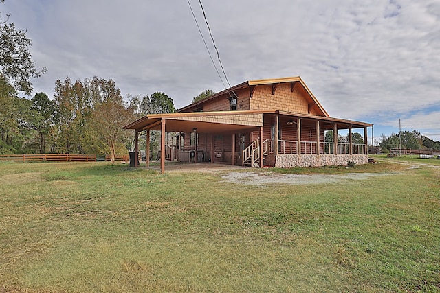 view of side of home featuring covered porch and a yard