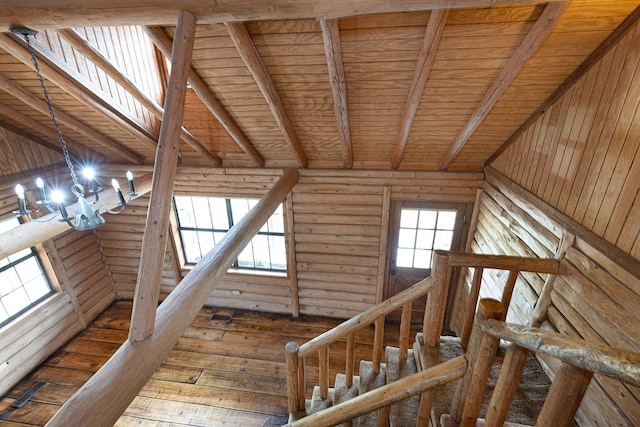 stairway featuring hardwood / wood-style flooring, a notable chandelier, wooden ceiling, and rustic walls