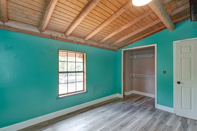 unfurnished bedroom featuring lofted ceiling with beams, a closet, wood ceiling, and light hardwood / wood-style flooring