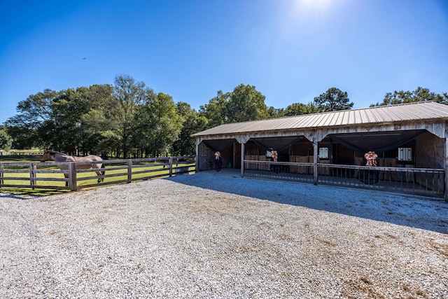 view of horse barn with a rural view