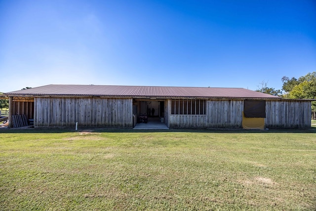 back of property with a lawn and an outbuilding