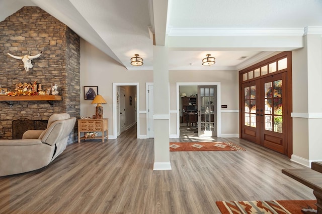 entrance foyer featuring french doors, ornamental molding, lofted ceiling, and hardwood / wood-style flooring