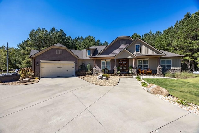 craftsman-style home featuring a porch, a garage, and a front yard