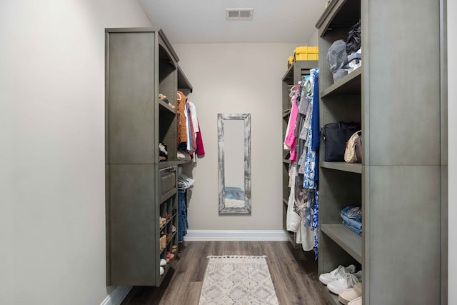 walk in closet with dark hardwood / wood-style flooring