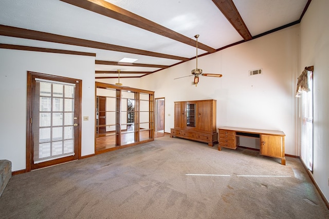 unfurnished living room featuring light carpet, visible vents, beam ceiling, and french doors