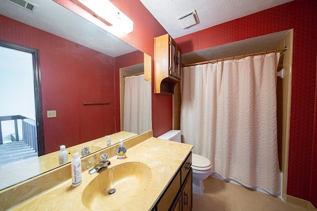 bathroom with visible vents, a textured ceiling, toilet, and vanity