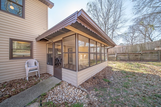 exterior space with fence and a sunroom