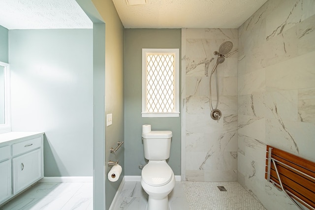 full bath with baseboards, tiled shower, toilet, marble finish floor, and vanity