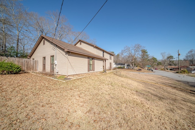 view of property exterior with a yard and fence